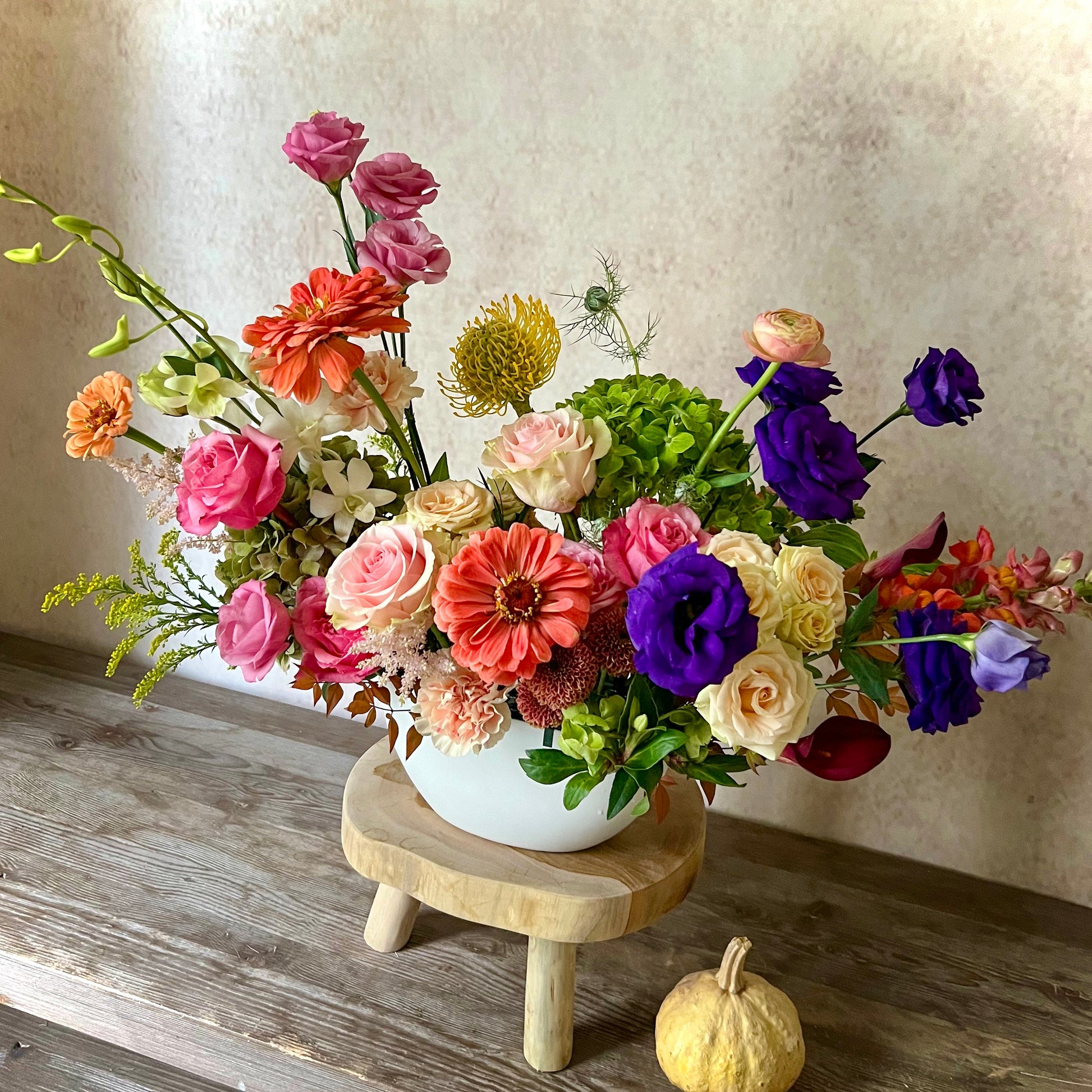 Vibrant fall flower arrangement with warm autumn colors – perfect autumn centerpiece for a dinner table or gift delivery.