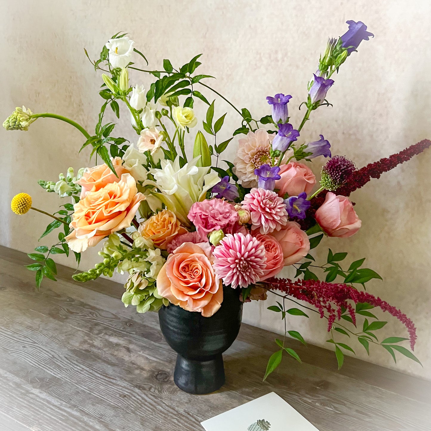 Standard floral arrangement featuring soft pink, coral, purple, and burgundy flowers in a stylish design – ideal for birthdays, thank you gifts, or brightening someone's day.